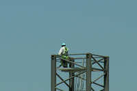 Worker standing on crane base.