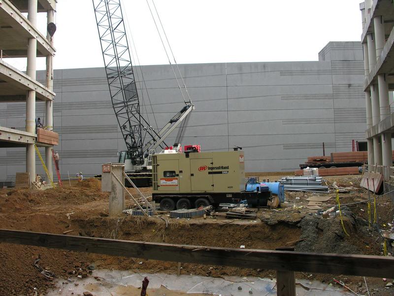 Portable crane helping to install concrete exterior panels; note that permanent crane installed at beginning of construction has been removed.