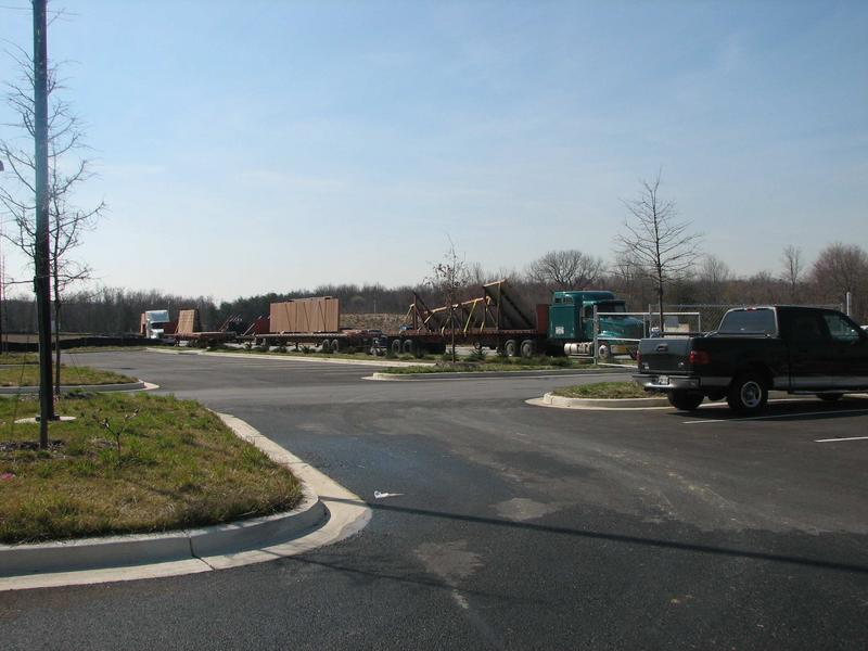 Trucks lined up on entrance road carrying concrete facade panels for building exterior