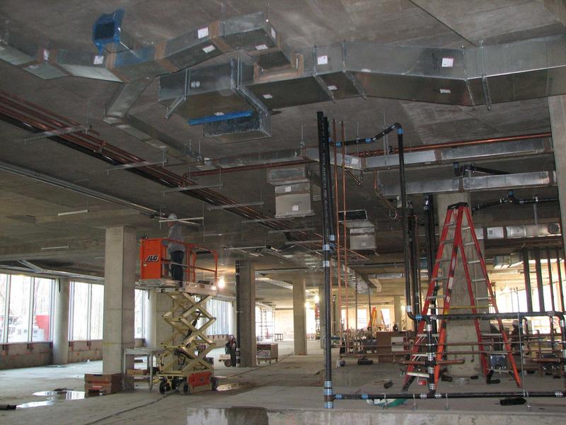 Ductwork and conduits being installed on first floor