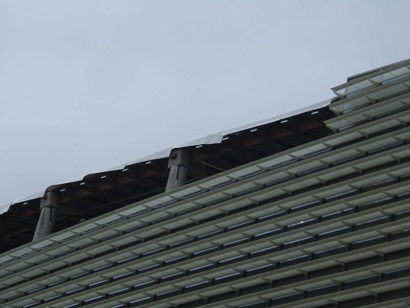 Closer view of roof showing installation of IRMA (Inverted Roof Membrane Assemblies) roofing. IRMA is a roofing assembly in which styrofoam insulation and ballast are placed over a roof membrane. Seen here is the membrane hanging over the edge.