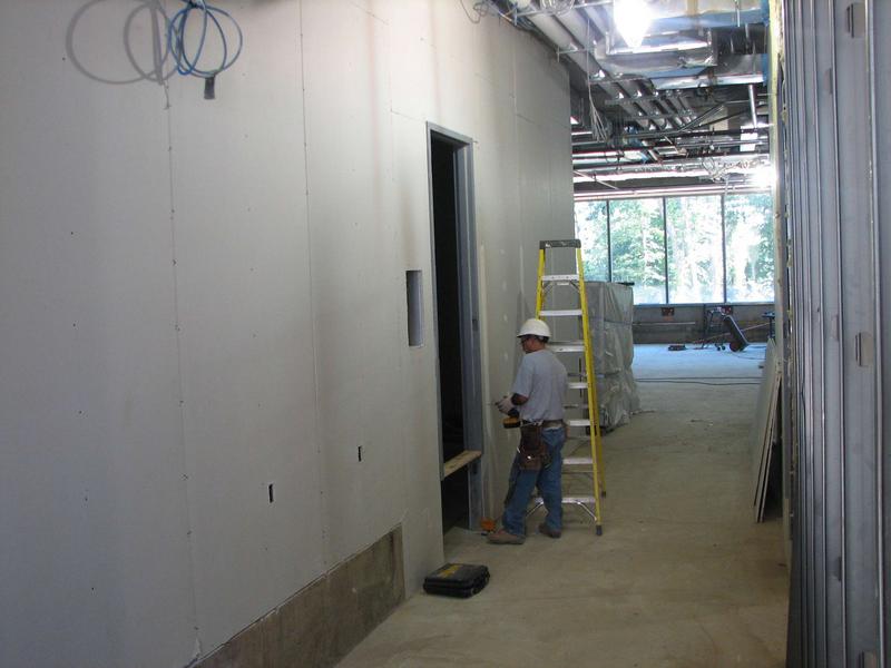 Drywall installation on ground floor. Note level of doorsill which reveals the height of the future raised flooring