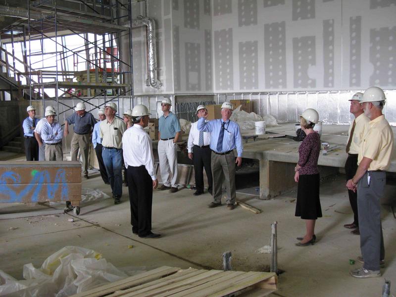 Stage area of auditorium. Project Manager Eric Livingston (in blue shirt) is conducting a tour for NCEP Center Directors