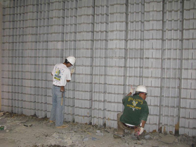 Workers constructing decorative wall facing on back wall of auditorium