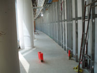 View of the employee entrance; the red posts mark where the security turnstile will be located.