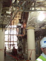 In the atrium, welders work to install the brackets where handrails will be connected.